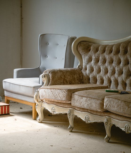 A person using a handheld vacuum cleaner to perform surface cleaning on a decorative yellow and white patterned cushion, which is placed on a dark fabric sofa in a well-lit room, demonstrating deep cleaning and upholstery sanitisation process as part of professional domestic cleaning services offered by Carpet Cleaning Kennington for Victorian homes on Kennington Lane.